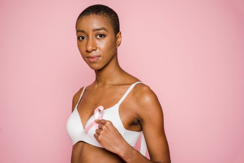 Empowering portrait of a woman with a pink breast cancer ribbon symbolizing awareness.