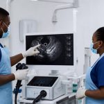A high-end, bright, and sterile clinical setting featuring a modern endoscopy or ultrasound diagnostic monitor